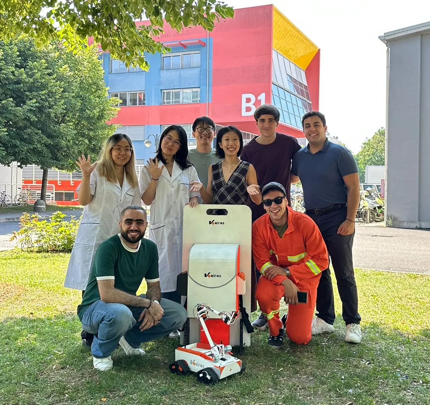 The Kairos team posing with the tracked robot and its carrying case